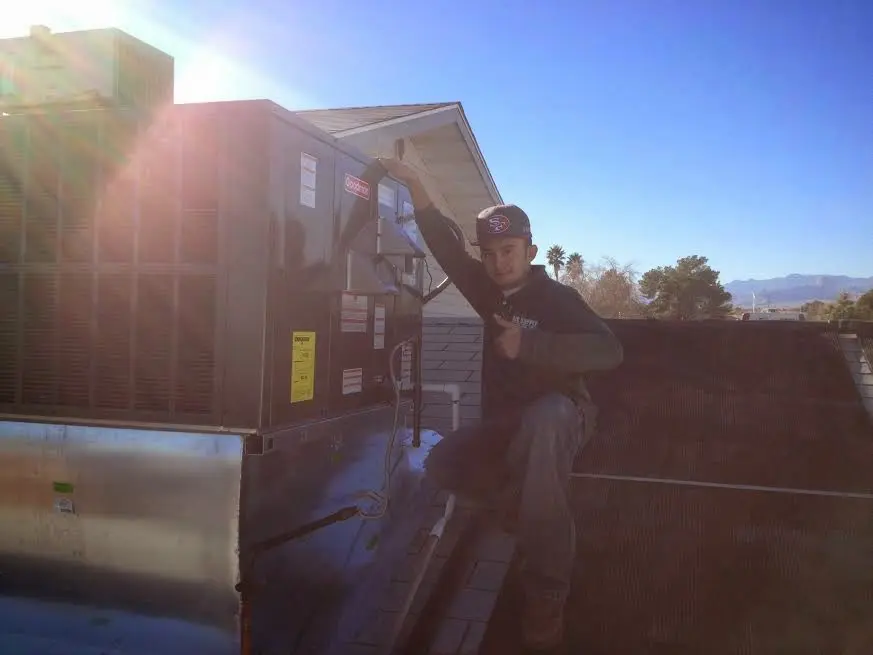HVAC technician performing Heat Pump Repair on a rooftop unit in Cherry Creek